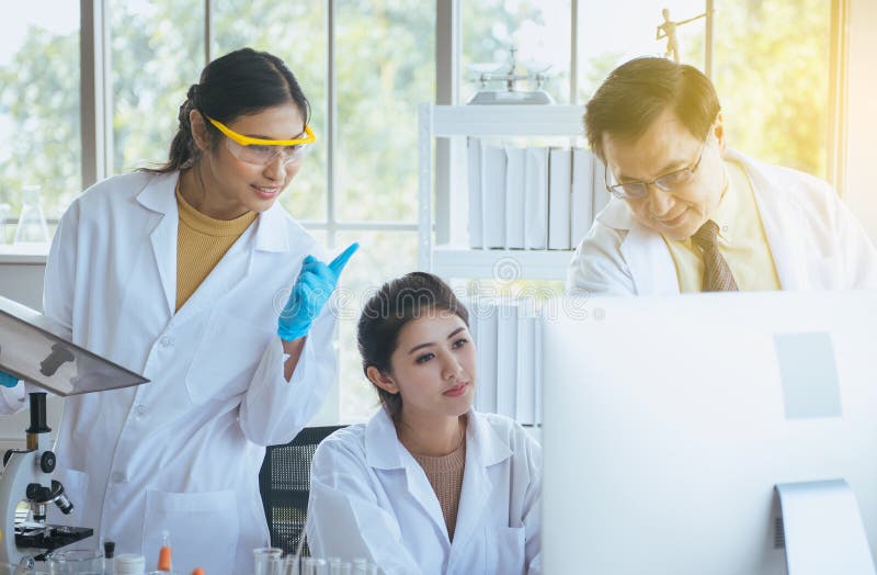 Mentor and students working together on research in a laboratory